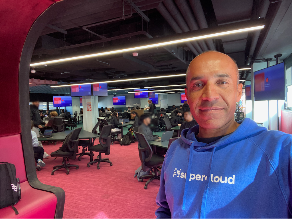 Steve is about to start a studio class where students design and build an app end-to-end. When Steve last walked these halls 30 years ago, they were all small, grey lab rooms and offices. The young ones love all the tech brands I wear (conference merch from over the years).